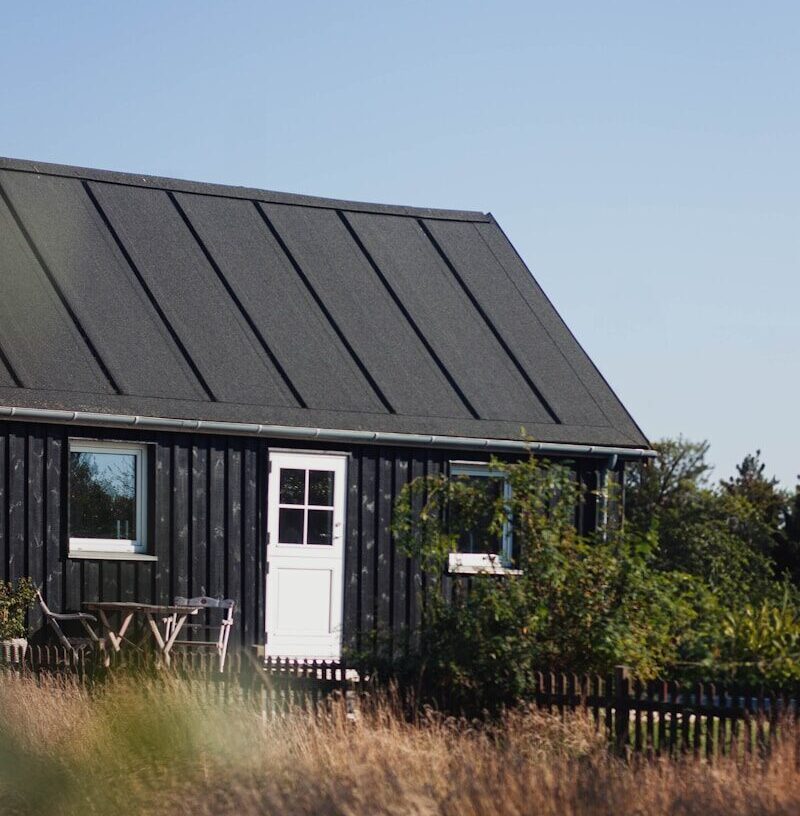 a small black house with a white door