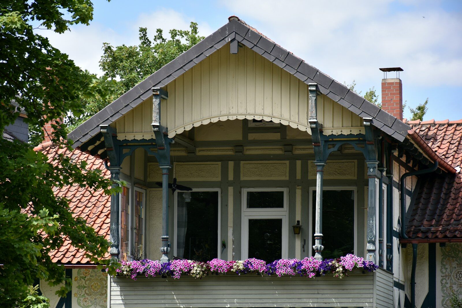 Ornate balcony with flowers and traditional architecture.